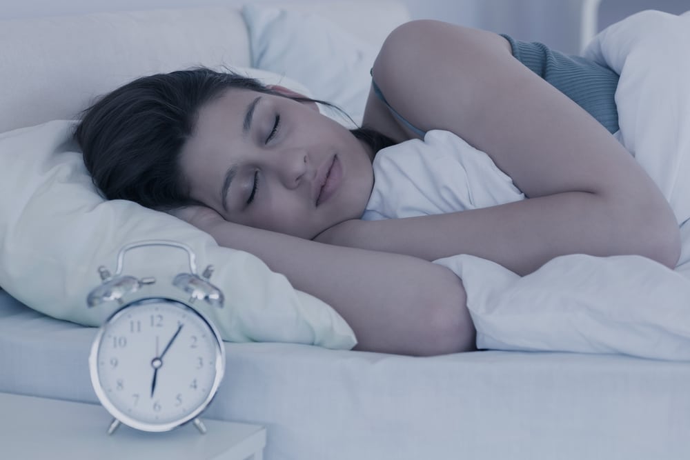 brunette sleeping in her bed at home in the bedroom