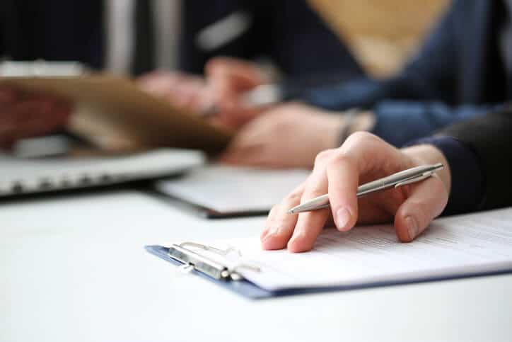 hand on clipboard with pen