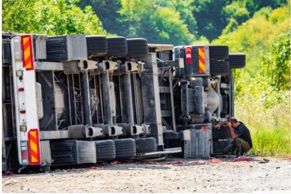 truck driver assess damage to truck after accident